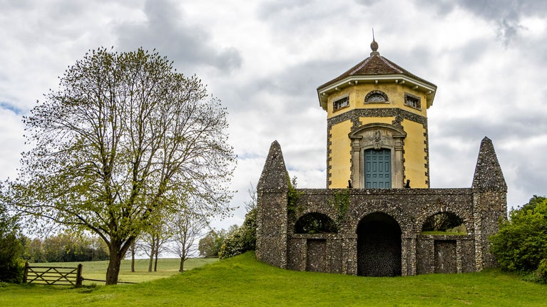 A temple designed in the classical style, a hexagonal, stone built and plastered temple sits atop a bare stone base with an arched opening